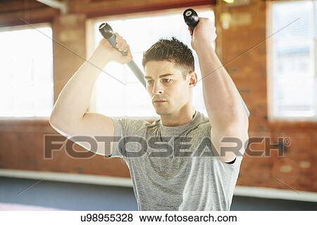 Man lifting weights in gymnasium View Large Photo Image Stock Photo - Man lifting weights in gymnasium. Fotosearch