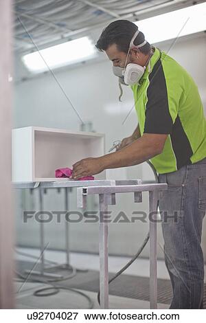 Man spraying wooden box in carpenters workshop View Large Photo Image Stock Photo - Man spraying wooden box in carpenters workshop. Fotosearch
