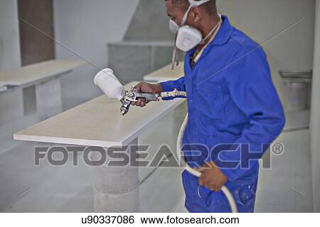 Man spraying wooden plank in carpenters workshop View Large Photo Image Stock Photograph - Man spraying wooden plank in carpenters workshop. Fotosearch