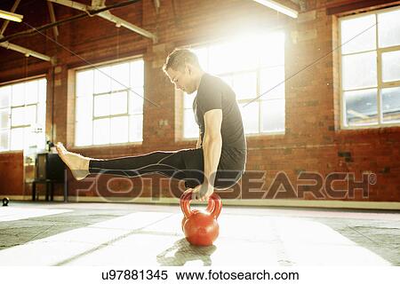 Stock Photography - Man strength training with kettle bells. Fotosearch