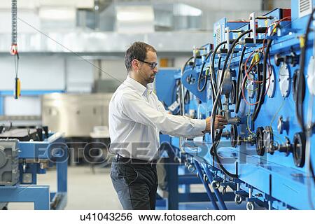 Stock Photograph - Manager monitoring industrial machinery. Fotosearch