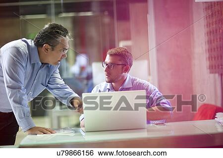 Mature businessman advising male office worker View Large Photo Image Stock Photograph - Mature businessman advising male office worker. Fotosearch