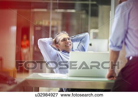 Mature businessman chatting to colleague View Large Photo Image Stock Photo - Mature businessman chatting to colleague. Fotosearch