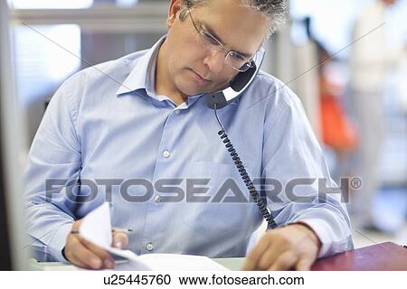 Mature businessman checking his diary View Large Photo Image Stock Image - Mature businessman checking his diary. Fotosearch