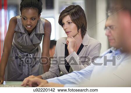 Stock Image - Mature businessman presenting ideas in office. Fotosearch