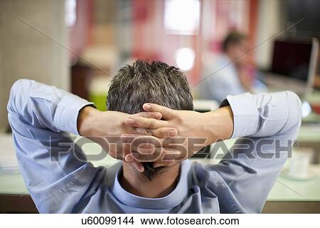 Picture - Mature businessman relaxing in office. Fotosearch