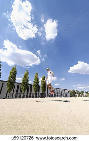 Mature man doing jump exercises in park View Large Photo Image Stock Photograph - Mature man doing jump exercises in park. Fotosearch