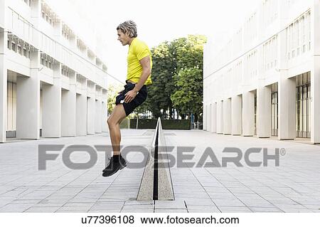Mature man jumping over divider View Large Photo Image Stock Photo - Mature man jumping over divider. Fotosearch