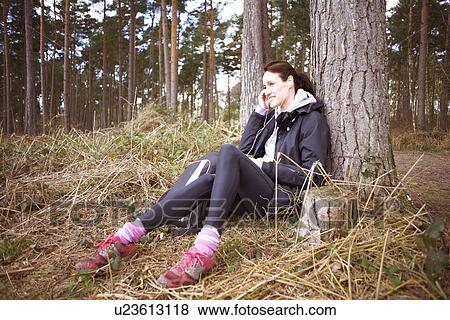 Mature woman runner talking on her cellphone in a forest View Large Photo Image Stock Photo - Mature woman runner talking on her cellphone in a forest. Fotosearch