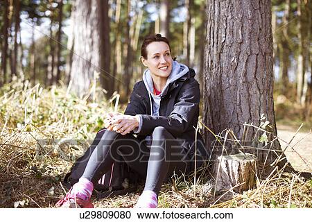 Mature woman taking a break in a forest View Large Photo Image Stock Image - Mature woman taking a break in a forest. Fotosearch