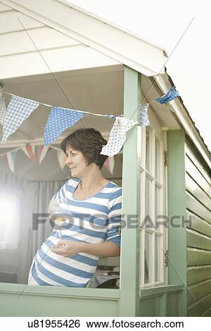 Mature woman with glass if white wine in beach hut porch View Large Photo Image Stock Photograph - Mature woman with glass if white wine in beach hut porch. Fotosearch