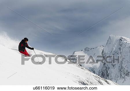Stock Photo - Mid adult male skiing on slope, Obergurgl, Austria. Fotosearch