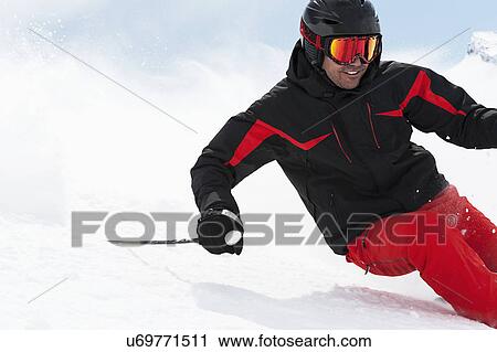 Stock Image - Mid adult man skiing downhill, Obergurgl, Austria. Fotosearch