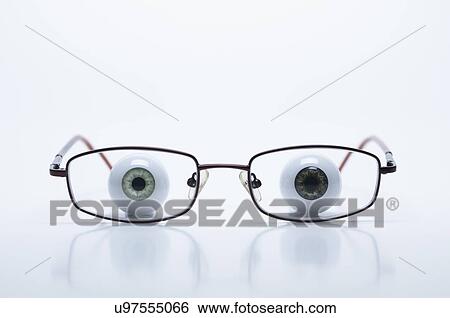 Stock Photograph - Model eyeballs behind spectacles with myopic (negative) lenses. Fotosearch