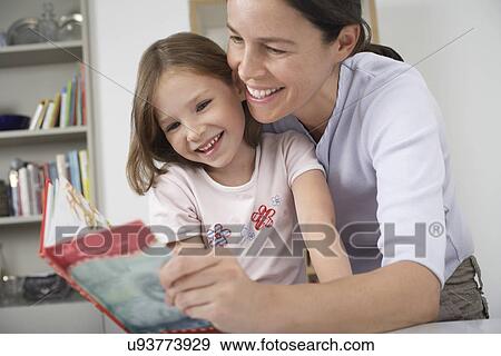 Mother and young daughter reading storybook View Large Photo Image Stock Photo - Mother and young daughter reading storybook. Fotosearch