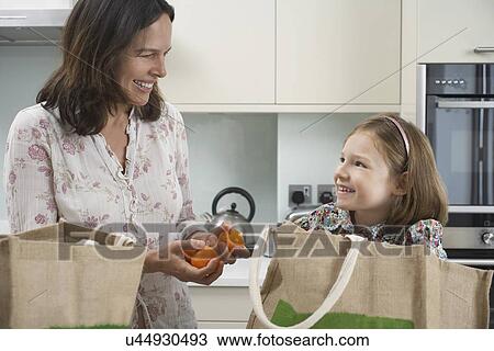 Mother and young daughter unpacking shopping bags View Large Photo Image Stock Image - Mother and young daughter unpacking shopping bags. Fotosearch