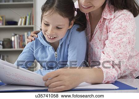Mother helping young daughter with homework View Large Photo Image Stock Photo - Mother helping young daughter with homework. Fotosearch