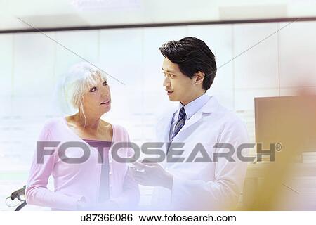 Pharmacist advising customer on medication View Large Photo Image Stock Photograph - Pharmacist advising customer on medication. Fotosearch