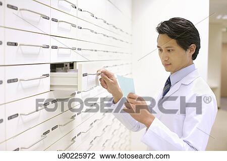 Stock Image - Pharmacist collecting medicines for prescription. Fotosearch