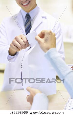 Pharmacist handing prescription bag to customer View Large Photo Image Stock Photo - Pharmacist handing prescription bag to customer. Fotosearch