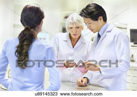 Pharmacists advising customer on medication View Large Photo Image Stock Image - Pharmacists advising customer on medication. Fotosearch