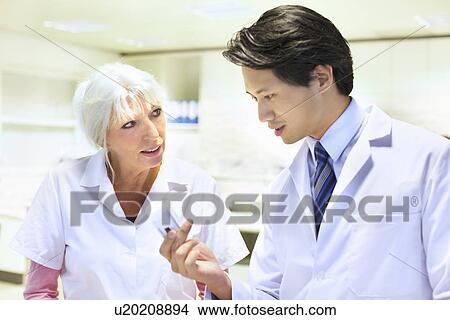 Pharmacists checking medicines in pharmacy View Large Photo Image Picture - Pharmacists checking medicines in pharmacy. Fotosearch
