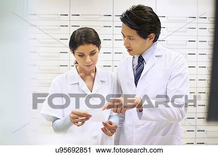 Pharmacists checking prescription in pharmacy View Large Photo Image Stock Image - Pharmacists checking prescription in pharmacy. Fotosearch