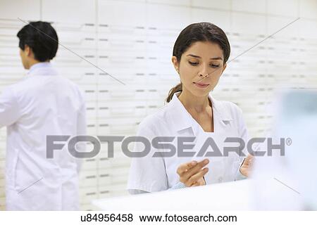 Stock Photo - Pharmacists collecting prescription in pharmacy. Fotosearch