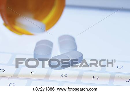 Stock Photograph - Pills on tablet keypad. Fotosearch