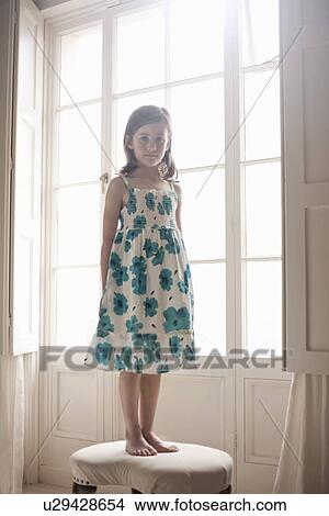 Portrait of a girl standing on a bedroom stool View Large Photo Image Picture - Portrait of a girl standing on a bedroom stool. Fotosearch