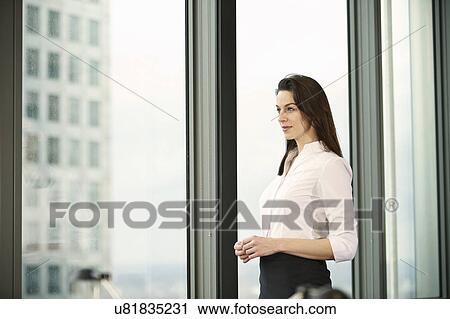 Stock Image - Portrait of businesswoman in high rise office. Fotosearch
