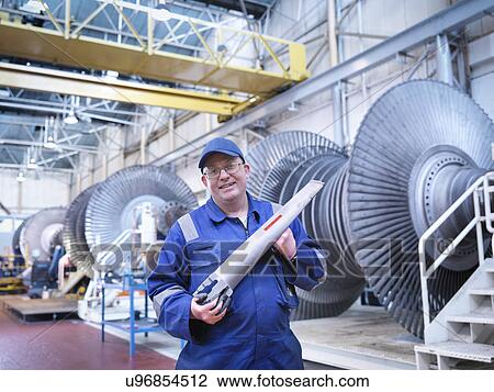Portrait of engineer holding rotor blade in turbine repair workshop View Large Photo Image Stock Image - Portrait of engineer holding rotor blade in turbine repair workshop. Fotosearch