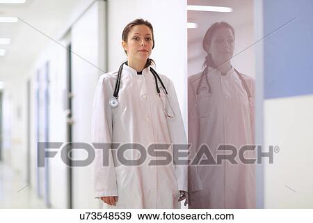Portrait of female doctor standing in hospital corridor View Large Photo Image Stock Photo - Portrait of female doctor standing in hospital corridor. Fotosearch