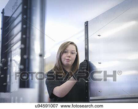Stock Photo - Portrait of female production line apprentice. Fotosearch