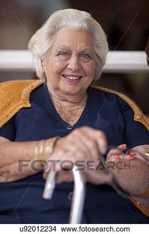 Portrait of happy senior woman holding walking stick View Large Photo Image Picture - Portrait of happy senior woman holding walking stick. Fotosearch