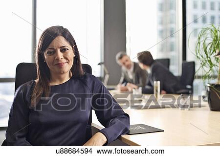 Portrait of mid adult businesswoman at office desk View Large Photo Image Picture - Portrait of mid adult businesswoman at office desk. Fotosearch