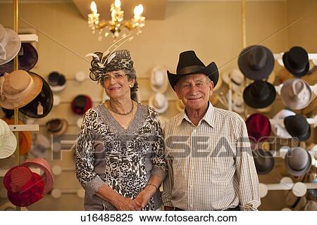 Stock Photography - Portrait of senior couple in traditional milliners shop. Fotosearch