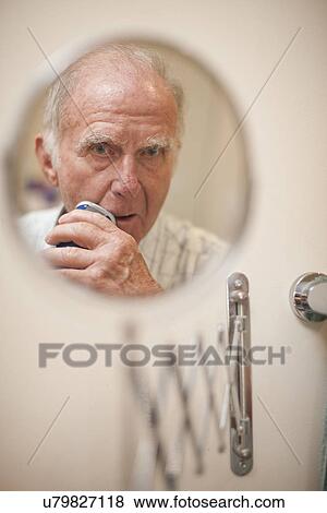 Portrait of senior man in shaving mirror using electric razor View Large Photo Image Stock Photo - Portrait of senior man in shaving mirror using electric razor. Fotosearch