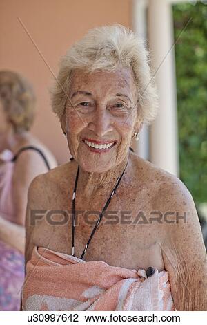 Stock Image - Portrait of senior woman wrapped in a towel. Fotosearch