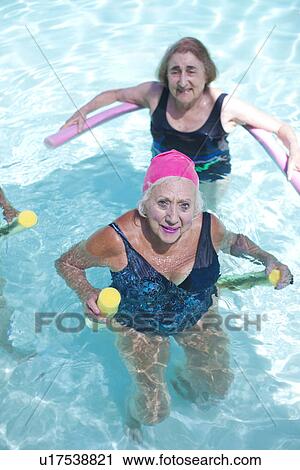 Stock Image - Portrait of senior women doing exercise in swimming pool. Fotosearch