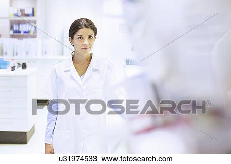 Portrait of young female pharmacist in pharmacy View Large Photo Image Stock Image - Portrait of young female pharmacist in pharmacy. Fotosearch