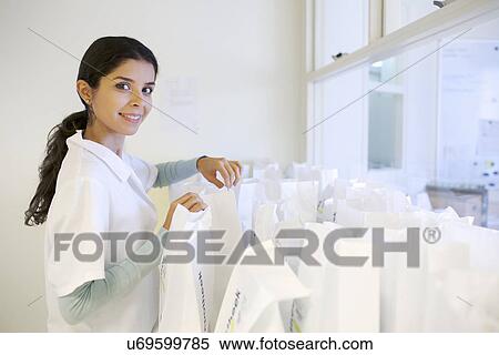 Portrait of young female pharmacist checking prescription bags View Large Photo Image Stock Photography - Portrait of young female pharmacist checking prescription bags. Fotosearch