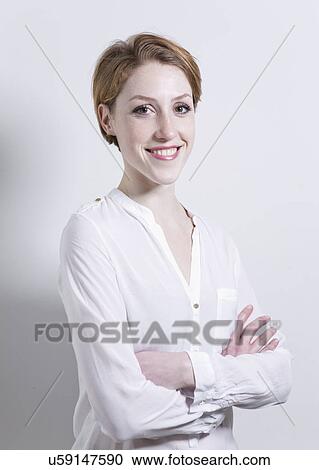 Stock Image - Portrait of young woman, arms crossed. Fotosearch