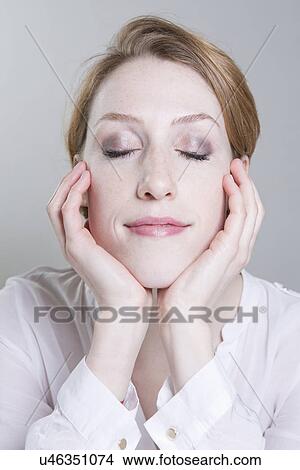 Portrait of young woman, chin on hands, eyes closed View Large Photo Image Picture - Portrait of young woman, chin on hands, eyes closed. Fotosearch