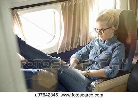 Portrait of young woman sitting on train with feet up View Large Photo Image Stock Photography - Portrait of young woman sitting on train with feet up. Fotosearch