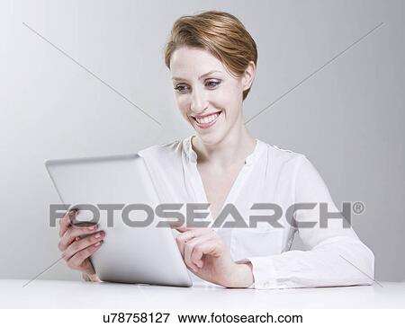 Portrait of young woman, using digital tablet View Large Photo Image Stock Photo - Portrait of young woman, using digital tablet. Fotosearch