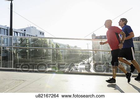 Picture - Runners crossing bridge, Munich, Germany. Fotosearch