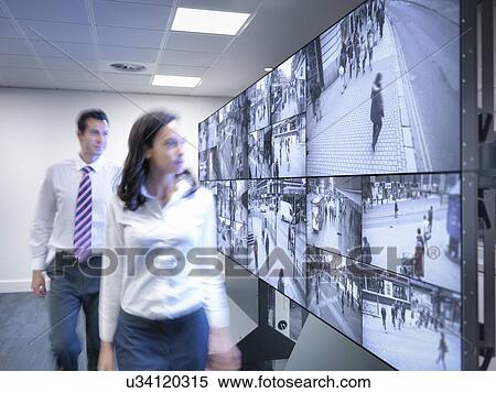 Security workers walking past CCTV screens in control room View Large Photo Image Stock Photography - Security workers walking past CCTV screens in control room. Fotosearch