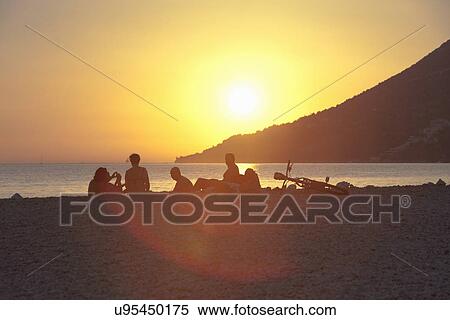 Small group of people watching sunset on beach, Vigan, Croatia View Large Photo Image Stock Photography - Small group of people watching sunset on beach, Vigan, Croatia. Fotosearch