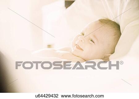 Smiling baby boy lying in crib View Large Photo Image Stock Image - Smiling baby boy lying in crib. Fotosearch